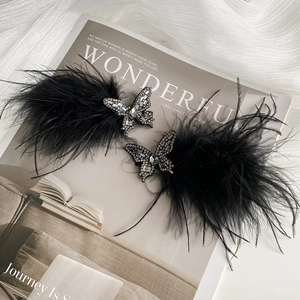 Elegant set of two black feather hair clips featuring rhinestone crystal butterflies