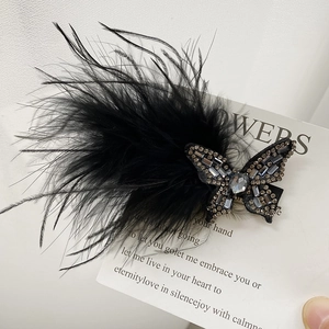 Detail view of the black feather bow hair clip with sparkling rhinestones and butterfly shape