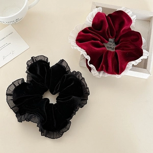 Détail de chouchous en velours avec bords en dentelle en noir et rouge bordeaux