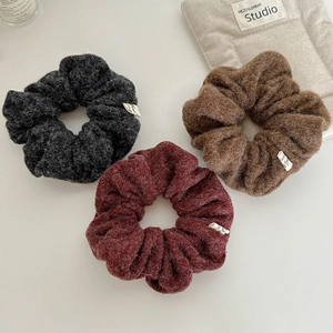 Detailed macro view of soft knitted winter scrunchies in gray, burgundy and brown colors