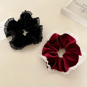 Détail de chouchous en velours noir et bordeaux avec bordure en dentelle élégante