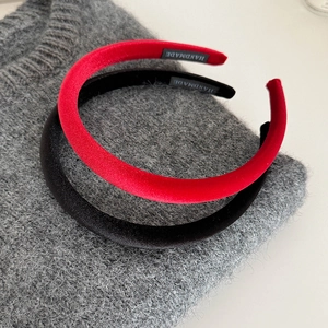 Detail of red and black velvet headbands with handmade label on knit fabric