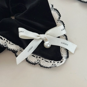 Nahaufnahme von Samt-Haargummi mit Spitzenborte, Lucky-Schleife und Perlenanhänger-Detail