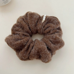 Detail of a large fluffy dark brown mohair scrunchie with soft plush texture for winter style