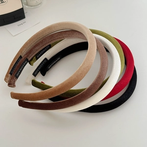 Detailed macro view of multi-colored velvet headbands featuring handmade textile labels