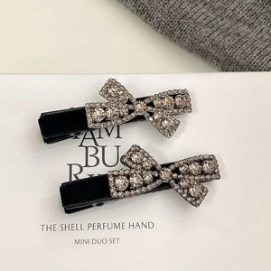 Elegant pair of black velvet bow hair clips with shimmering rhinestone decorations