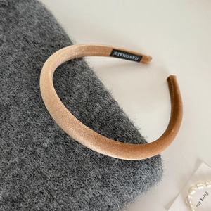 Detail of caramel velvet headband showing soft texture and handmade woven label