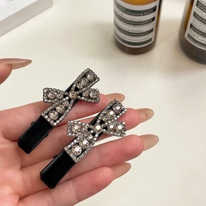 Elegant pair of black flocked bow hair clips with champagne rhinestones for women