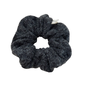 Charcoal grey plush scrunchie with soft lamb wool texture and minimalist woven label