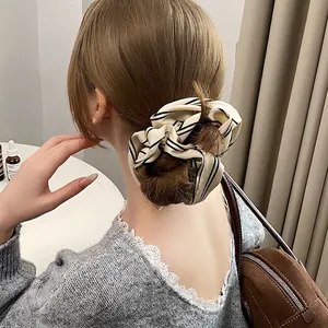 Elegant oversized striped satin scrunchie shown on a ponytail for hair styling