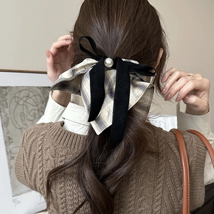 Detail of vintage plaid bow scrunchie with velvet ribbons and pearl on knitted sweater