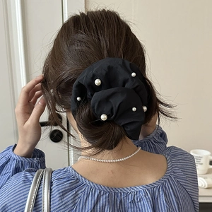 Chouchou noir style français avec perles blanches sur une coiffure élégante