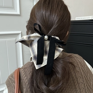 Detail of vintage plaid bow hair scrunchie with velvet ribbons and a pearl accent