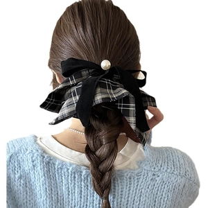 Plaid bow scrunchie with pearl detail on a braided hairstyle for women's retro style