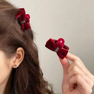 Elegant burgundy velvet bow hair clips with shimmering black rhinestone accents for women