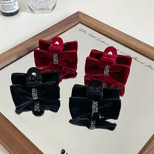 Detailed close-up of velvet bow hair clips with rhinestone accents on a vanity display