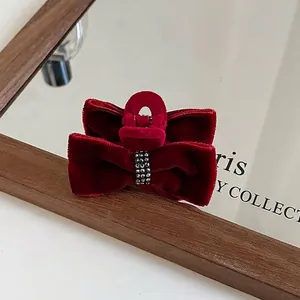 Close-up of wine red velvet bow hair claw clip with sparkling silver rhinestones