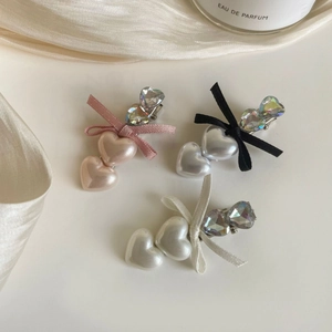 Detail of pink, silver, and cream heart hair clips with rhinestones and ribbon bows
