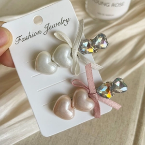 Detail of elegant bow heart hair clips with rhinestones on a jewelry display card