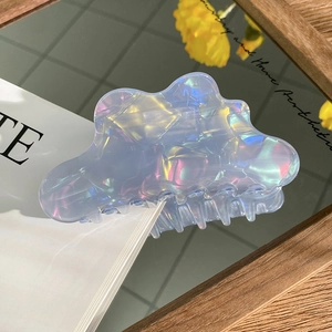 Iridescent light blue cloud hair claw clip with pearlescent finish on aesthetic background