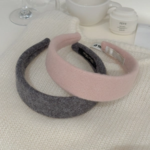 Detail of thick wool felt headbands in grey and pink with handmade label and soft texture