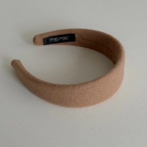 Detailed macro view of the inner side of a wide wool headband showing Hand Made label