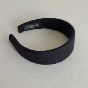 Close-up of handmade label on a black wool wide headband with soft texture