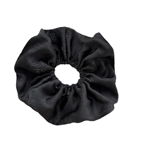 Elegant black satin scrunchie with embossed camellia pattern on a clean white background