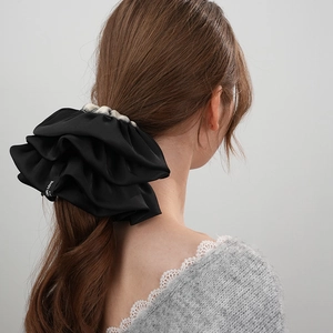 Dettaglio dell'elastico scrunchie in raso nero con etichetta FOR LOVE e bordi a quadretti