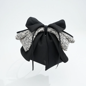 Detail shot showing the multi-layer bow hair clip with floral print and black satin ribbons