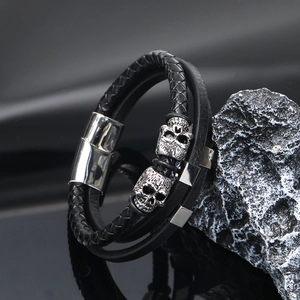 Men's multi-layer black braided leather bracelet with silver skull charms and magnetic clasp