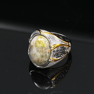 Macro di anello vintage da uomo con pietra verde e dettagli pavé neri sulla fascia laterale
