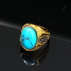 Dettaglio macro di anello d'oro vintage con grande turchese e cristalli neri incastonati