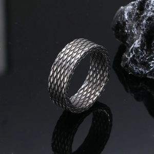 Macro detail of men's stainless steel ring with diamond grid pattern and vintage finish