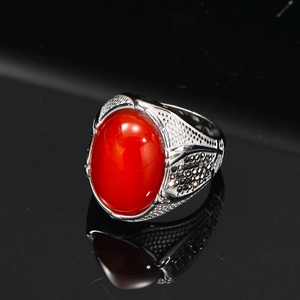 Dettaglio anello vintage da uomo con grande gemma rossa e accenti neri in acciaio inox