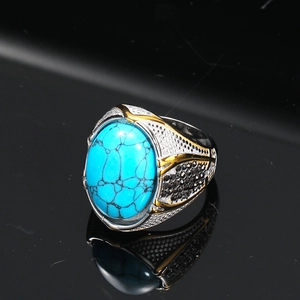 Dettagli macro dell'anello da uomo con turchese, toni argento e oro e pietre nere