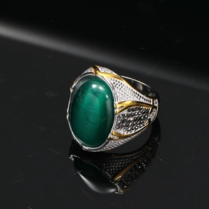 Vista macro dell'anello vintage da uomo con pietra occhio di gatto verde e dettagli argento