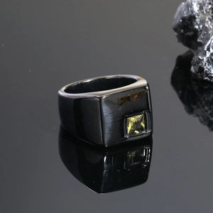 Detalle macro del anillo de sello negro para hombre en acero con gema cuadrada amarilla