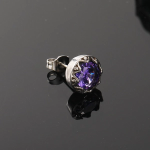 Gros plan d'une boucle d'oreille rétro en acier titane avec gemme violette et serti couronne