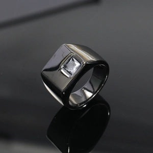 Primer plano de un anillo de sello negro pulido con una piedra preciosa cuadrada transparente