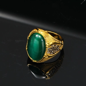 Macro di anello dorato con gemma verde occhio di gatto ovale e incisioni vintage
