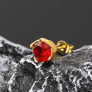 Macro shot of a faceted red ruby stud earring set in a vintage golden leaf-shaped base