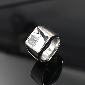 Primer plano de anillo de diamante cuadrado plateado con banda de acero pulido