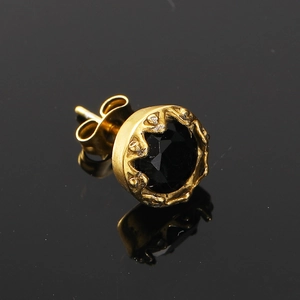 Vue rapprochée d'une boucle d'oreille dorée vintage avec pierre noire facettée