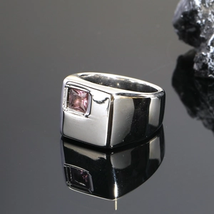 Primer plano de un anillo de banda ancha cuadrada con una piedra preciosa rosa brillante