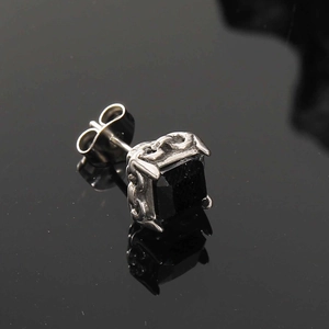 Makroaufnahme von gotischem schwarzem Zirkon-Ohrring mit filigraner Vintage-Metallgravur