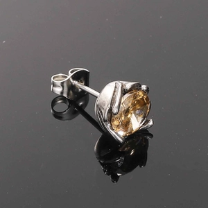 Macro view of a champagne gemstone stud earring with retro silver metal setting