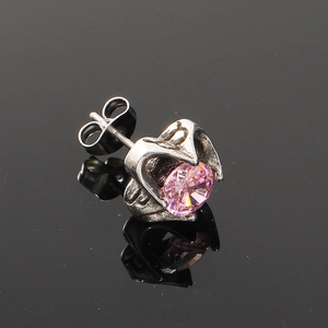 Détail d'un clou d'oreille en zircon rose avec serti griffes argenté et fermoir papillon