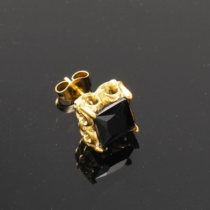 Dettaglio ravvicinato di orecchino retrò con zircone nero e motivi floreali in oro