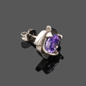 Détail d'une boucle d'oreille en argent avec pierre violette facettée et fini vintage